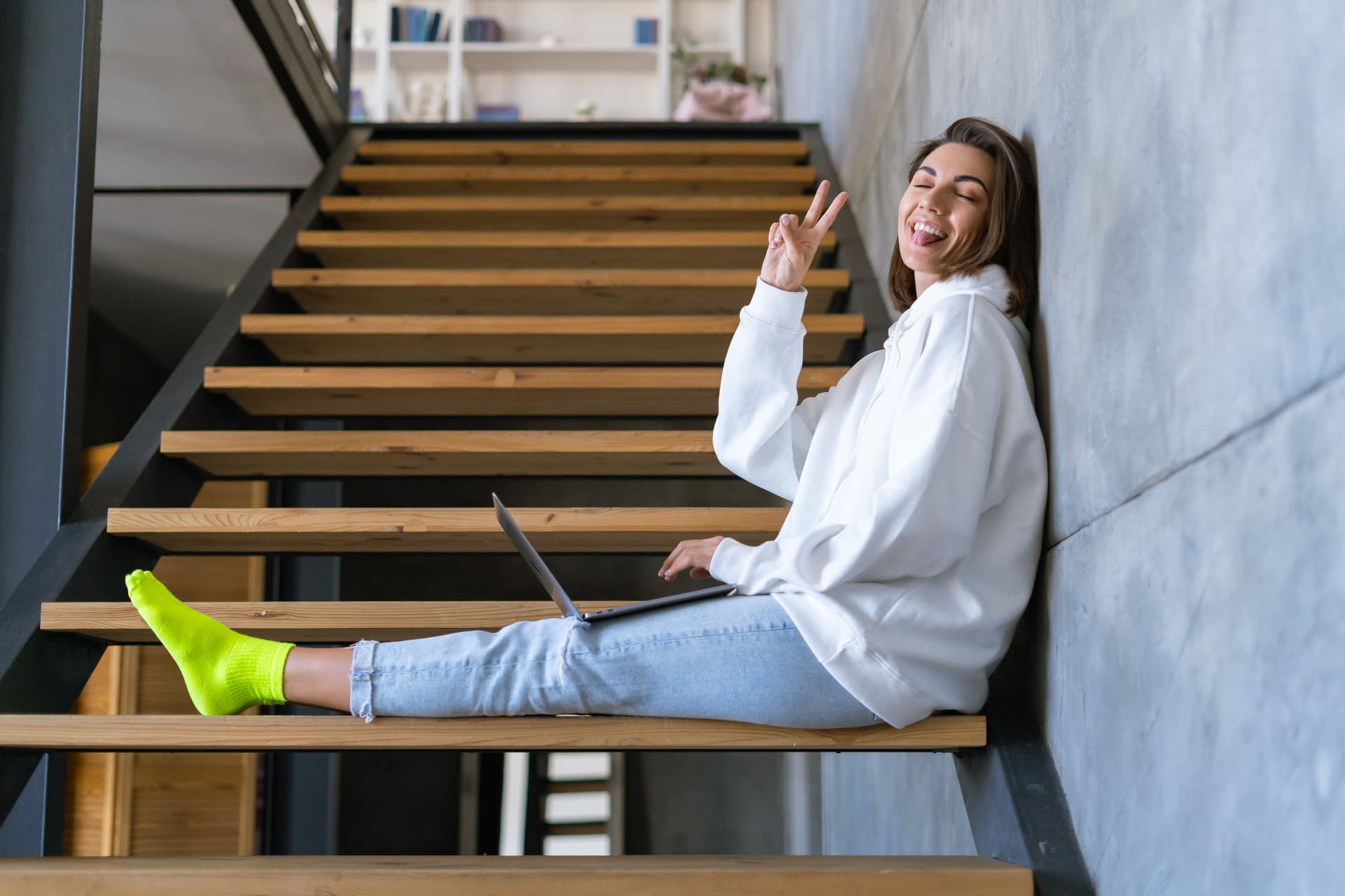 mujer joven sentada sobre una escalera de madera